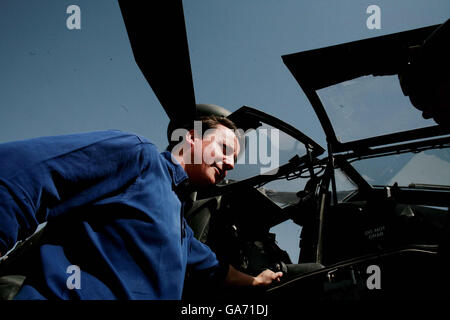 Der konservative Parteivorsitzende David Cameron schaut am letzten Tag seiner zweitägigen Erkundungsmission bei einem Besuch in Camp Bastion, Süd-Afghanistan, auf einen Apache-Hubschrauber. Stockfoto