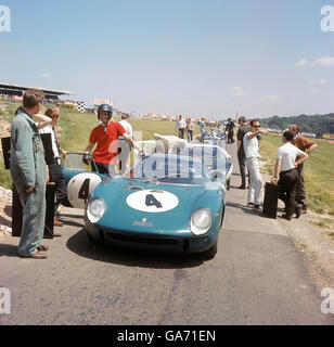 Peter Clarke scherzt mit seinen Mechanikern und Zeitmessern vor einem Übungslauf mit seinem Ferrari 275 LM bei den LMC Radio London Car Races in Brands Hatch, Kent Stockfoto