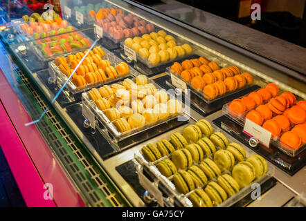 Französische Macarons in leuchtenden Farben locken die Naschkatze Shopper Gourmet-Stil in den Reihen der Anzeige in einem Kühler im Gebäck sh Stockfoto