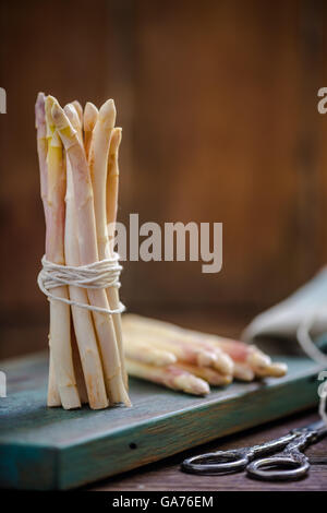 Reihe von frischen weißen Spargel auf rustikalem Holzbrett Stockfoto