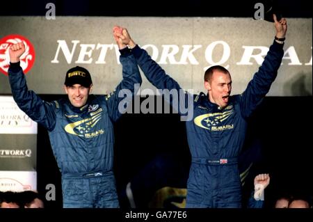 Richard Burns (r) feiert mit seinem Mitfahrer Robert Reid (l) nach dem Sieg bei der Rallye-Weltmeisterschaft mit dem dritten Platz bei der Network Q Rally of Great Britain Stockfoto