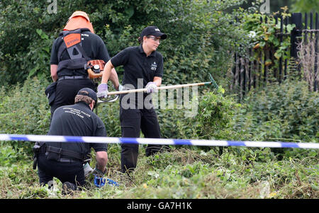 Polizeibeamte durchsuchten die Szene hinter dem Pub Fir Tree in Croxteth, Liverpool, nachdem der 11-jährige Rhys Jones am Mittwochabend getötet wurde. Stockfoto