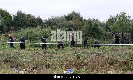 Polizeibeamte durchsuchten die Szene hinter dem Pub Fir Tree in Croxteth, Liverpool, nachdem der 11-jährige Rhys Jones am Mittwochabend getötet wurde. Stockfoto