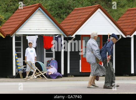 Urlauber wärmen sich heute am Bournemouth Beach in Dorset gegen die Elemente, wo der goldene Sand wegen des schlechten Augustwetters fast völlig leer war. Stockfoto