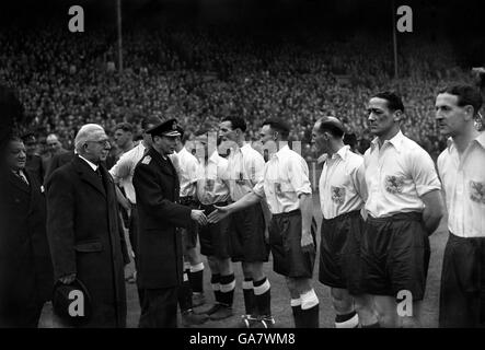 König George VI schüttelt sich die Hände mit Mitgliedern des Millwall-Teams vor dem Auftakt in diesem Krieg Cup-Finale. Stockfoto