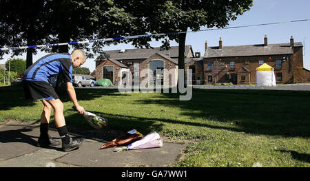 Ein Junge legt Blumen an der Szene vor dem Pub Fir Tree in Croxteth, Liverpool, wo der 11-jährige Rhys Jones letzte Nacht getötet wurde. Stockfoto