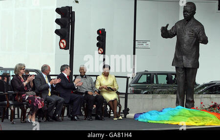 Eine Statue des ehemaligen südafrikanischen Präsidenten Nelson Mandela wird heute auf dem Parliament Square gegenüber dem Londoner Parlamentsgebäude enthüllt, während Mandela und seine Frau Graca Machel, Premierminister Gordon Brown und der Londoner Bürgermeister Ken Livingstone auf sie blicken. Stockfoto