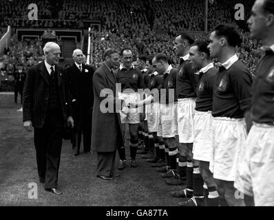 HM King George VI schüttelt sich vor dem FA-Cup-Finale in Wembley mit einigen Mannschaften der Manchester United die Hände. Stockfoto