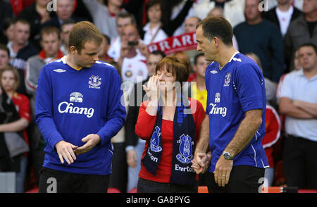 Die Eltern des ermordeten Schuljungen Rhys Jones, Melanie (Mitte) und Stephen Jones (rechts), stehen mit ihrem älteren Sohn Owen (links), als die Everton Fußballclubhymne Z Cars vor dem Champions League Third Qualifying Round Second Leg Match in Anfield, Liverpool, zwischen Liverpool und Toulouse gespielt wird. Stockfoto