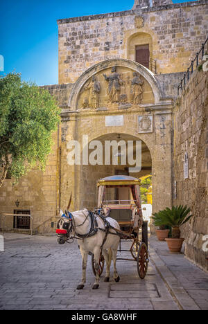 Malta, Mdina: Karrozzin, das traditionelle maltesische Pferdetaxi wartet am Haupttor auf Touristen. Stockfoto