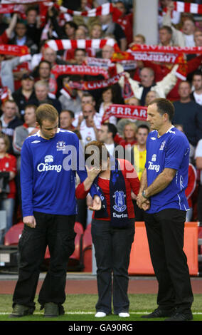 Die Eltern des ermordeten Schuljungen Rhys Jones, Melanie (Mitte) und Stephen Jones (rechts), stehen mit ihrem älteren Sohn Owen (links), als die Everton Fußballclubhymne Z Cars vor dem Champions League Third Qualifying Round Second Leg Match in Anfield, Liverpool, zwischen Liverpool und Toulouse gespielt wird. Stockfoto