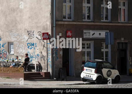 Ein Café mit einem smart Auto vorne in der alten Vorstadt von Danzig, Polen, ein Beispiel der Regeneration in den Vororten. Stockfoto