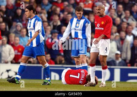 David Beckham von Manchester United liegt am Boden verletzt als Sein Teamkollege Juan Sebastian Veron (r) geht, um sich der zu stellen Offender Deportivo La Coruna's Aldo Duscher (l) Stockfoto