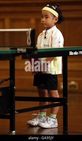 Japanisches Tischtennis-Wunderkind Mima Ito, 6, während eines Spiels gegen Veteran Tischtennis-Champion Edna Fletcher, 81, in der Great Yarmouth Town Hall, Norfolk statt. Stockfoto