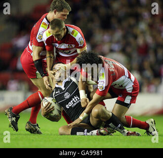 St. Helens' Maurie Fa'asavalu wird von Stuart Fielden (links) Gareth Hock (Mitte) und Thomas Leuluai während des Engage Super League-Spiels im JJJB Stadium, Wigan, zu Boden gepackt. Stockfoto