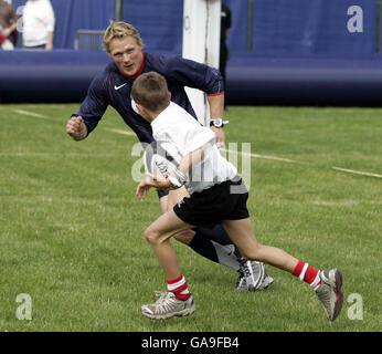 Ein junger Spieler versucht, Josh Lewsey beim O2 Scrum in the Park Day im Regents Park, London, zu passieren. Stockfoto