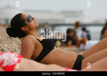 Sonnenanbeter genießen die letzte Sommersonne am Brighton Beach, Sussex. Stockfoto