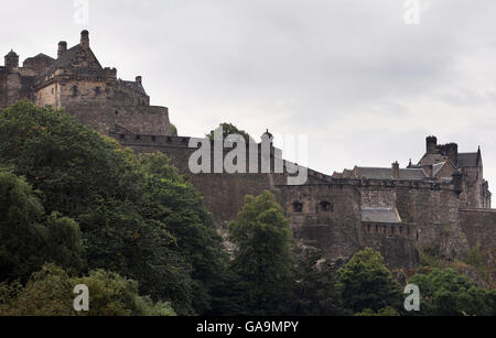 Arbeiter hängen an Seilen, während sie die Felswände der Burg von Edinburgh aufragen, um neue Büsche und Bäume zu entfernen. Stockfoto