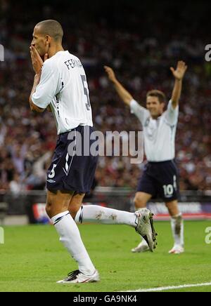 Der englische Rio Ferdinand (links) feiert das dritte Tor des Spiels, während Teamkollege Michael Owen seine Hände in die Luft legt, um zu feiern. Stockfoto