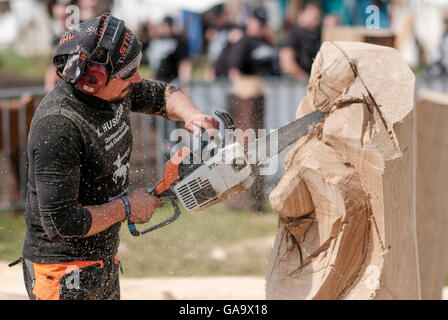 Wacken, Deutschland. 4. August 2016. Metalllüfter schneiden eine hölzerne Skulptur mit einer Kettensäge auf dem Gelände das Wacken Open Air Festival in Wacken, Deutschland, 4. August 2016. Das Gelände von der laut den Organisatoren ist größte Metal-Festival nach starken Regenfällen im Schlamm bedeckt. Foto: AXEL HEIMKEN/Dpa/Alamy Live News Stockfoto