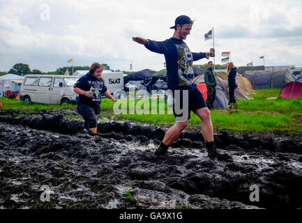 Wacken, Deutschland. 4. August 2016. Metal-Fans geht durch den Schlamm auf dem Gelände das Wacken Open Air Festival in Wacken, Deutschland, 4. August 2016. Das Gelände von der laut den Organisatoren ist größte Metal-Festival nach starken Regenfällen im Schlamm bedeckt. Foto: AXEL HEIMKEN/Dpa/Alamy Live News Stockfoto