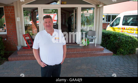 Sumte, Deutschland. 1. August 2016. Jens Meier, Kreis-Geschäftsführer (lit. Bezirksleiter) des Arbeiter-Samariter-Bund (ASB, beleuchtet. Samariter Transportarbeiter-Föderation), stellt außerhalb des Zentrums der Notunterkunft für Flüchtlinge in Sumte, Deutschland, 1. August 2016. Das Dorf mit einer Bevölkerung von nur 102 Schlagzeilen die im Herbst letzten Jahres, nach mehr als 700 Flüchtlinge untergebracht waren. Zunächst soll die Zahl so hoch wie 1.000 gewesen sein. Derzeit bleiben nur rund 20 Flüchtlinge in Sumte. Foto: Philipp Schulze/Dpa/Alamy Live News Stockfoto