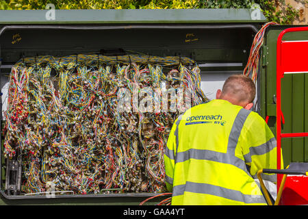 Gelbe Weste Hi-Vis BT OpenReach Reparaturingenieur, auf der Straße Schränke, Kabel, Arbeiten an einem Labyrinth von Glasfaser-Breitbanddrähten in Southport, Merseyside, Großbritannien, August 2016. Das BAKOM hat heute Fortschritte bei den Maßnahmen zur digitalen Kommunikation, ADSL-Breitbandkit und -Arbeit für alle angekündigt – einschließlich einer umfassenden Reform von OpenREACH. Die Kampagnengruppe sagt, dass Open REACH aufgrund der Einführung weiterer Verbesserungen des Service „radikale Veränderungen“ bedarf. Stockfoto
