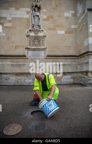 Eton, UK. 5. August 2016. Ein Pavenet Auftragnehmer installiert einen Marker für die Eton Gehweg vor einer Statue des Bischofs Waynflete an der Wand des Eton College Chapel im Namen der Outdoor Trust and Eton Community Association. Die zwei-Meile Gehweg verbindet 18 bedeutende Sehenswürdigkeiten rund um die historische Stadt. Bildnachweis: Mark Kerrison/Alamy Live-Nachrichten Stockfoto