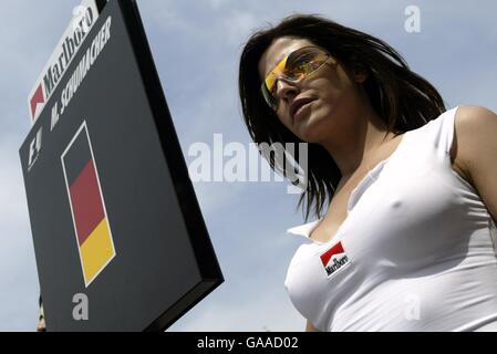 Mit einem Schild, das den Namen des Polesitters sagt, steht Michael Schumachers Grid-Girl stolz Stockfoto