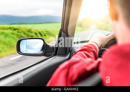 Männliche Fahrer fährt ein Cabrio auf der Landstraße. Der Blick aus der Kabine, Rückansicht, innen. Stockfoto