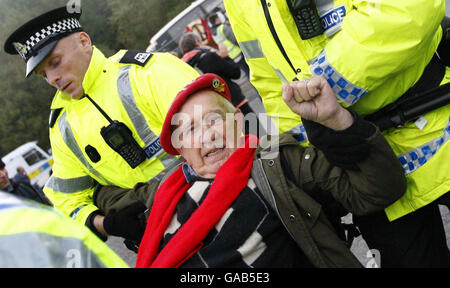 Ein Protestler wird am letzten Tag eines einjährigen Anti-Atom-Protests auf dem Marinestützpunkt Faslane von der Polizei mitgenommen. Stockfoto