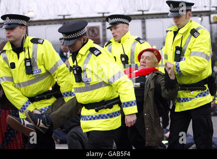 Ein Protestler wird am letzten Tag eines einjährigen Anti-Atom-Protests auf dem Marinestützpunkt Faslane von der Polizei mitgenommen. Stockfoto