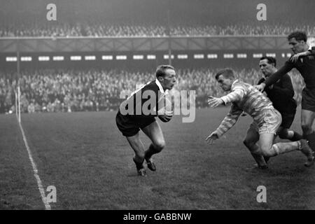 Rugby Union - Oxford University / Cambridge University - Twickenham. Peter Dawkins, der Amerikaner in Oxford, kommt mit dem Ball weg, als er kurz vor dem Angriff von D.F.B Wrench aus Cambridge steht. Stockfoto