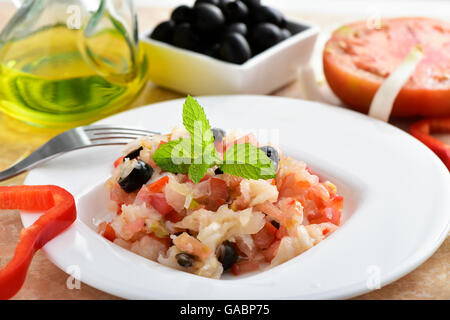 Nahaufnahme eines Tellers Esqueixada de Bacalla, ein kaltes Gericht mit Kabeljau, rote Paprika, Tomaten, Zwiebeln und schwarzen Oliven und Kleid Stockfoto