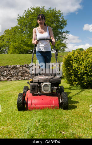 Lady Mähen Wiese im Garten mit Benzin betriebene Rasenmäher. Hawes, North Yorkshire, UK. Stockfoto