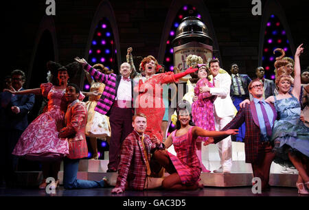 Die Besetzung des Musicals 'Hairspray', einschließlich (Mitte links bis rechts) Mel Smith (als Wilbur Turnblad), Michael Ball (Edna Turnblad), Leanne Jones (als Tracy Turnblad) und Ben James-Ellis (weißer Anzug, als Link Larkin) während einer Fotoanstellung im Shaftesbury Theatre im Zentrum von London. Stockfoto