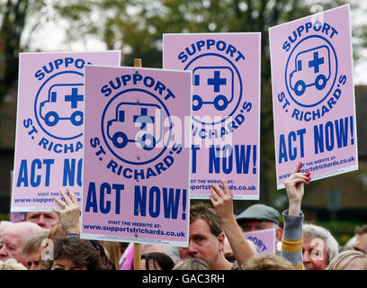 Demonstranten halten Plakate während einer Kundgebung im Priory Park Chichester, Sussex, gegen vorgeschlagene Kürzungen der Dienste im St. Richard's Hospital. Stockfoto