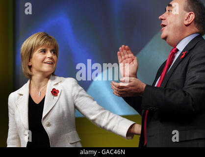 Die Gesundheitsministerin und stellvertretende SNP-Vorsitzende Nicola Sturgeon (links) steht mit dem Parteivorsitzenden Alex Salmond (rechts) nach ihrer Rede auf der Jahrestagung der Scottish National Party in Avimore, Schottland, zusammen. Stockfoto