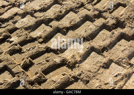 Hintergrund mit Fußspuren im Sand von schweren Maschinen Stockfoto