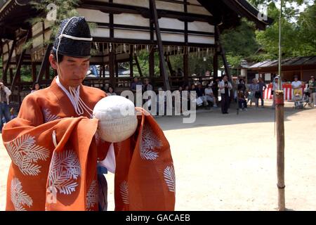 Ein Kemari-Spieler hält den mit Hirsch bedeckten Ball, der mit Sägemehl gefüllt und mit Pferdehaut zusammengebunden ist Stockfoto