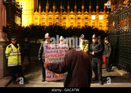 Ein Friedensproter demonstriert vor der Polizei vor den Houses of Parliament im Zentrum Londons. Stockfoto