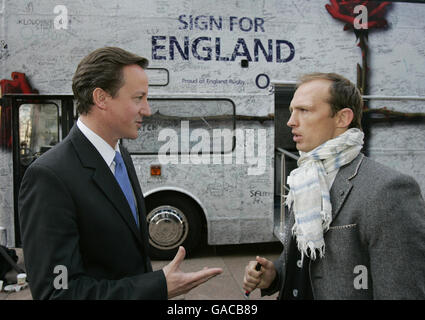 Der konservative Parteivorsitzende David Cameron spricht mit dem ehemaligen englischen Rugby-Spieler Matt Dawson, nachdem er den „Good Luck England“-Bus im Zentrum von London unterzeichnet hatte, bevor er zum Rugby-Weltcup-Finale in Paris abfährt. Stockfoto