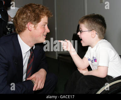 Der britische Prinz Harry, links, spricht mit Christopher Anderson, rechts, der Caroline Anderson, Mitte, während der Children Health Awards Ceremony in London für die beste Krankenschwester nominiert hat. Stockfoto