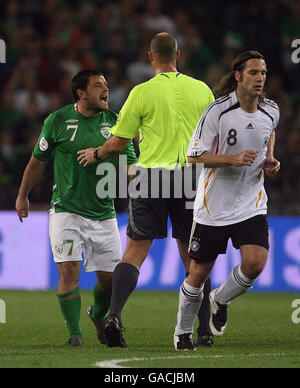 Andy Reid von der Republik Irland (links) hat sich mit dem Schiedsrichter nach einem Zusammenstoß mit Torsten Frings (rechts) aus Deutschland während des UEFA-Europameisterschafts-Qualifikationsspiel im Croke Park, Dublin, bekannt. Stockfoto