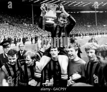 Manchester City Kapitän Tony Book hält den FA Cup hoch, während seine Teamkollegen um ihn herum feiern: (l-r) Glyn Pardoe, Francis Lee, Neil Young (halb versteckt), Mike Doyle, Torwart Harry Dowd, Colin Bell, Alan Oakes Stockfoto