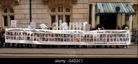 Angehörige von Patienten mit Clostridium difficile - einer bakteriellen Darminfektion - enthüllen ein Banner mit 80 Opfern der Krankheit, nach einem heutigen marsch nach Westminster. Stockfoto