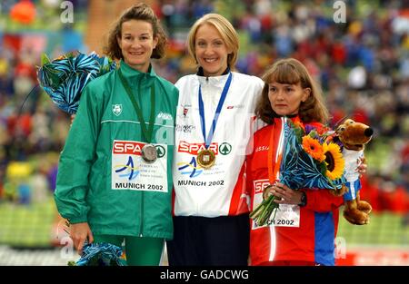 Mit der britischen Paula Radcliffe feiert sie ihren Goldmedaillengewinn Irlands Silbermedaillengewinnerin Sonia O'Sullivan (l) und Russlands Bronzemedaillengewinnerin Ljudmila Biktaschewa (r) Stockfoto