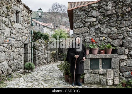 Eine ältere Witwe in der alten mittelalterlichen Straßen von Linhares, Serra da Estrela, Portugal Stockfoto