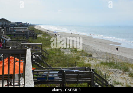 Zahlen gehen und laufen auf dem Sand in Long Beach, Oak Island, NC, in den frühen Morgenstunden. Stockfoto