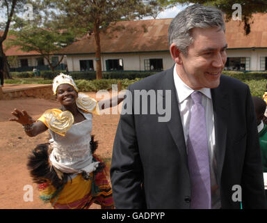 Premierminister Gordon Brown wird von traditioneller Musik und Tanz an der St. Peter's Primary School in Nsambya, in der Nähe der ugandischen Hauptstadt Kampala, begrüßt, wo das Commonwealth Heads of Government Meeting (CHOGM) stattfindet. Stockfoto